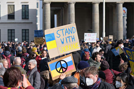 People with Ukrainian anti war placards protesting against the war in Ukraine by Brandenburg Gate.のeditorial素材