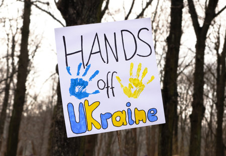 Text Hands off Ukraine on white packard. Closeup on packard with with text and hand prints with...
