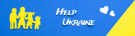 Ukrainian family, yellow paper silhouette. Text Help Ukraine. Flat lay, top view on blue yellow paper background, Ukraine flag colors.の写真素材