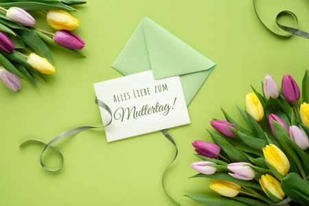 Alles Liebe zum Muttertag text, flat lay with colorful tulips, flat lay on paper with ribbons.の写真素材