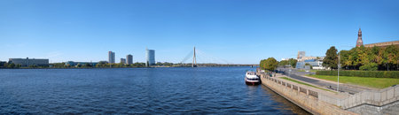 Panoramic view of the Baltic Capital of Riga Latvia from the riverside with tourist ship and modern...