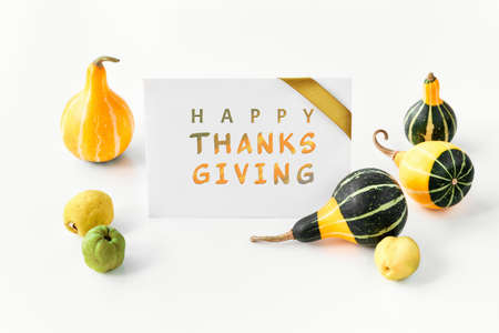 Greeting card, text Happy Thanksgiving. Natural Autumn decorations. Decorative Fall pumpkins and quince. Copy-space, place for text on paper card.の写真素材