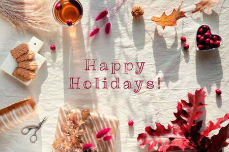 Text Happy Holiday with chrysanthemum flowers, dry bunny tail grass and red oak leaves, pumpkins, cranberry.の写真素材