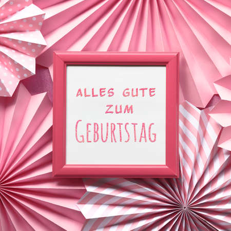 Pink paper fans, text Alles Gute zum Geburtstag means Happy Birthday in white frame. Flat lay, top view.の写真素材