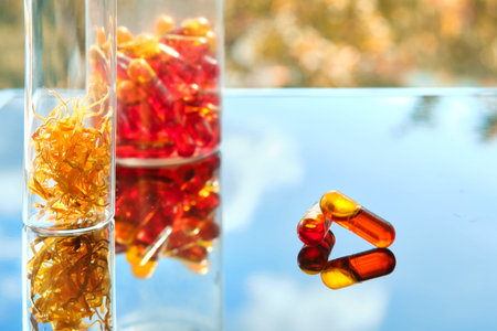 Curcumin in liquid form. Herbal capsules, herb turmeric capsules on neutral background with palm...