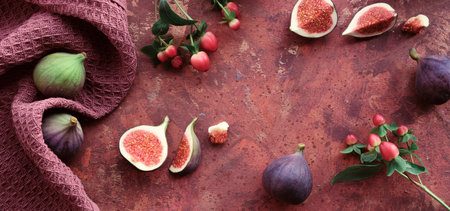 Fresh halved fig fruits and dry euvalyptus and cala lily flowers painted metallic pink on bstract textured background.の写真素材