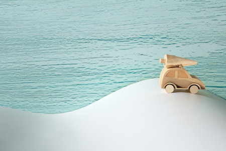 Wooden toy, silhouette of Christmas tree on toy car on off white and mint green background. Xmas holiday, snow background. Copy-space, place for text, greeting. Simple, minimal design.の写真素材