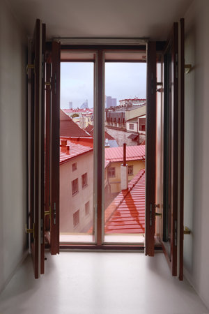 Old wooden window with view on roofs and towers in Tallin, Estonia. Aerial view over roofs of Tallinn through open window.の写真素材