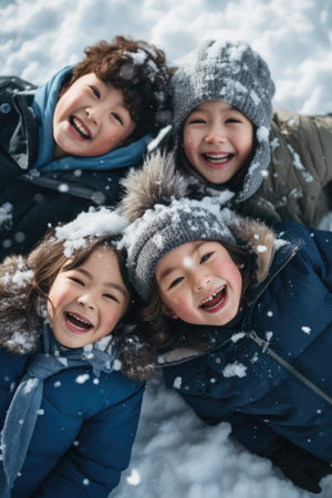 A group of children laying on top of a snow covered groundの素材