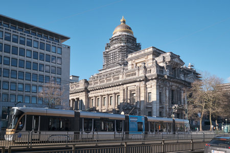 A tram on the tracks in front of Palace of Justice, a large abandoned court building in Brussels, Belgium.のeditorial素材