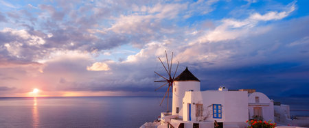 Windmill in Oia village on Santorini island, Greece, panoramic banner image.の写真素材