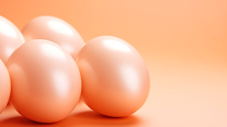 A group of eggs sitting next to each other, on peach fuzz background.の素材