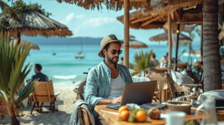 A man sitting at a table with a laptop in exotic locationの素材