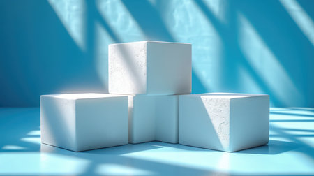 Three white cubes sitting on top of a blue surfaceの素材