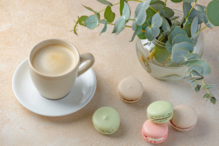 A cup of coffee and some macarons on a tableの素材