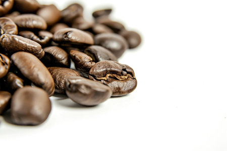 A pile of coffee beans on a white surfaceの素材