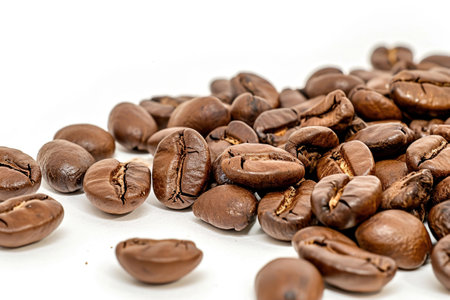 A pile of coffee beans on a white surfaceの素材