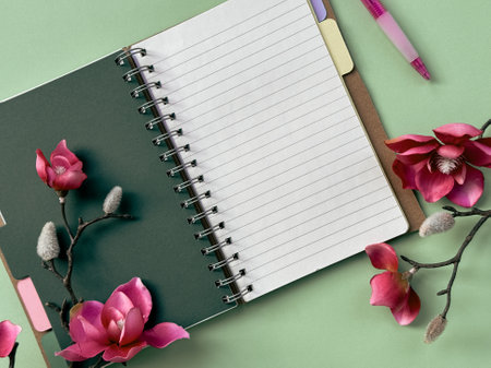 Notebook With Pink Flowers on a Green Background Pink magnolia flowers.の写真素材