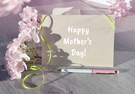 A Mothers Day Card Next to Some Flowersの写真素材