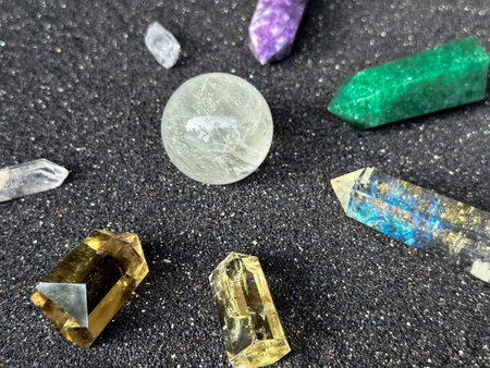 Colorful Crystals and Gemstones on Black Sand Surface Close-Up
