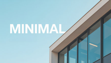Contemporary architectural design featuring a minimalist building facade with expansive glass windows. The word "MINIMAL" is displayed on a clear blue sky, emphasizing simplicity.の素材