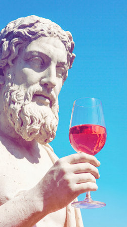 Classical statue holds a glass of rose wine against a vivid blue sky with sunlight accentuating weathered marble and a relaxed timeless mood, with ample open space for text or design on the rightの素材