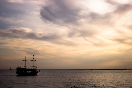 Silhouette of a sailboat right at sunset on a calm support in the chain of the island