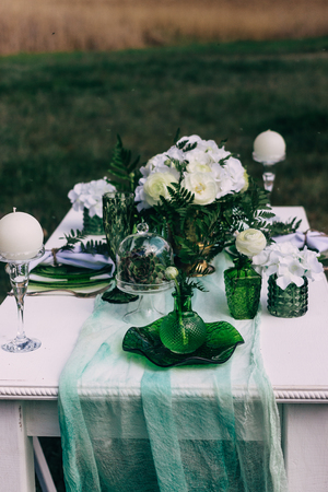 A colorful bouquet of freshly picked wild flowers from a natural meadow and garden. Presented on a table outdoors in a Clear Round Bubble Bowl Glass Vase.の写真素材