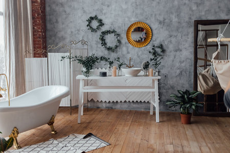 Cozy bathroom interior background with big white bathtub, natural green plant and rustic decoration...