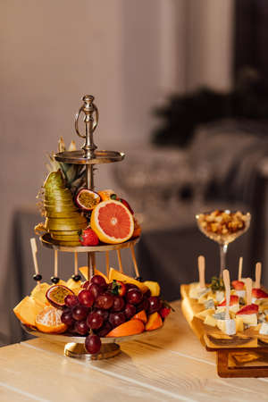 a plate of fruit stands on a wooden table covered for the holidayの写真素材