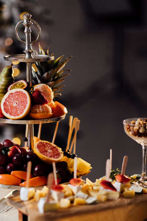 Fresh fruits in plate on wooden table. Variety of cut fruits. Assorted fruits. Kiwis, grapes, oranges, bananas, apples, pears.の写真素材