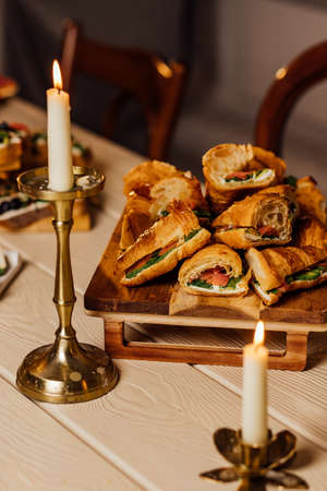 Croissant sandwich with cream cheese, salmon and arugula on a white plate, pink background, copy space, top view. healthy breakfast conceptの写真素材