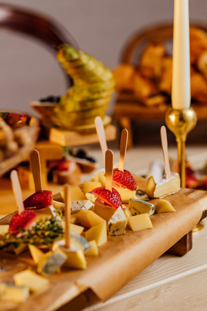 Cheese platter with different cheeses, grapes, nuts, honey, bread and dates on rustic wooden...