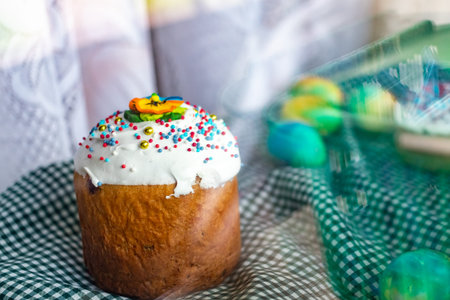 Festive cakes with white glaze, nuts and raisins with Easter eggs on the festive table. Preparations...