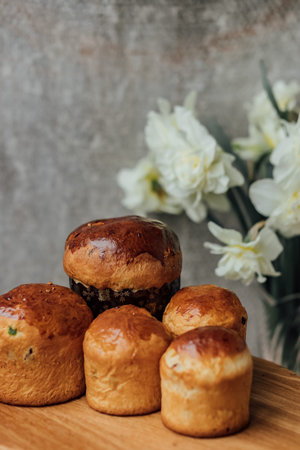 Delicious Easter cakes on a wooden table with flowers in the background. place for text. selective...