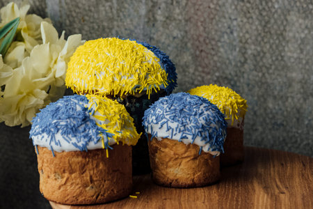 Delicious Easter cakes on a wooden table with flowers in the background. place for text. selective...
