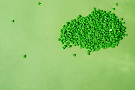 GREEN WAX GRANULES LIE ON A GREEN BACKGROUND.の写真素材
