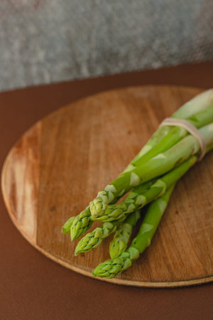 branches of fresh green asparagus on a wooden background, top view