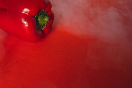 SWEET, fresh RED PEPPER ON RED BACKGROUND With smoke around, pepper. photo for the menu, proper nutrition. fresh vegetables.の写真素材