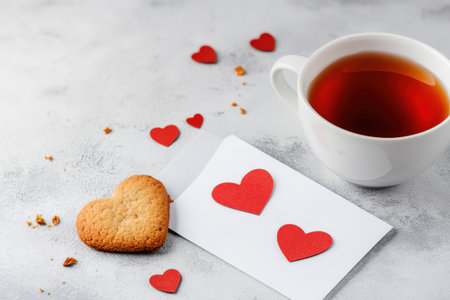 Valentine's day card with heart-shaped cookie and tea on gray background.の写真素材