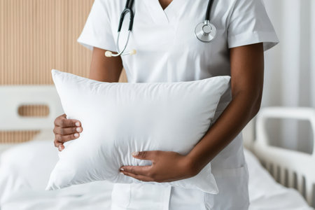 Healthcare worker holding pillow in hospital room.の写真素材