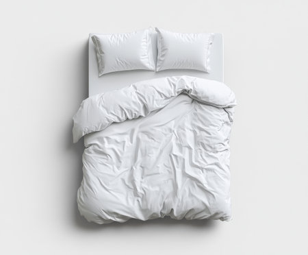 Top view of unmade minimalist white bed with crumpled bedding and pillows.の写真素材