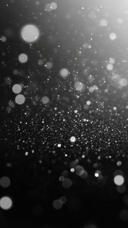Abstract black and white glittering light particles in dark background.の写真素材