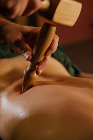 Relaxing wooden massage therapy on Asian adult female back.の写真素材