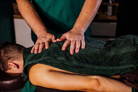 Male receiving professional relaxation back massage therapy session with focus on muscle relief.の写真素材