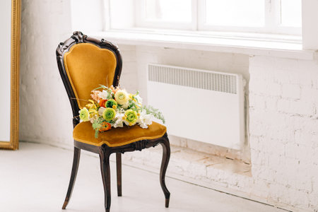 Vintage chair with colorful flower bouquet in bright room.の写真素材