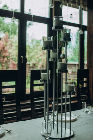 Elegant table setting with tall candle holders in a sunny dining room.の写真素材