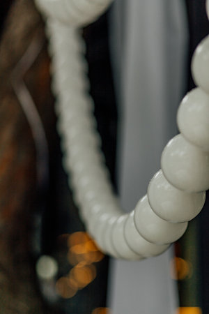 Close-up of white bead necklace with blurred background and warm lighting.の写真素材