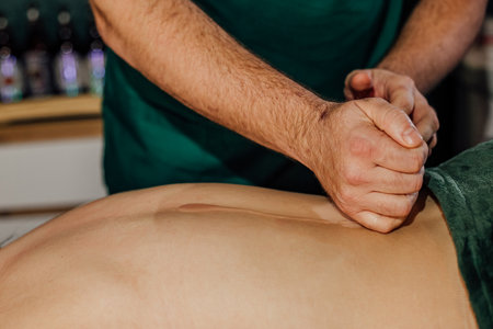 Therapist performing deep tissue massage on client in spa setting.の写真素材