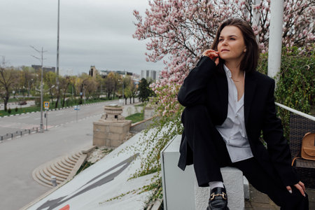 Young female enjoying spring day outdoors with blossoming trees.の写真素材